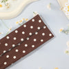 ربطة رأس مطاطية بنقاط ملونة على سطح أزرق فاتح مع زهور بيضاء صغيرة.