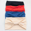 Ein Stapel von vier weichen elastischen breiten Stirnbändern in Schwarz, Rot, Blau und Beige.