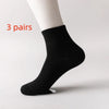 Three pairs of black men's mid-calf cotton socks displayed on a white background.