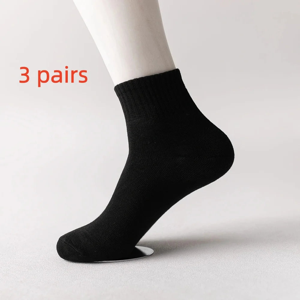 Three pairs of black men's mid-calf cotton socks displayed on a white background.