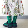 A pair of green embroidered cotton socks worn by a person, displayed against a light background.