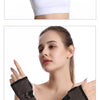A woman wearing a white sports bra and black copper fiber wrist bracers for fitness.