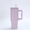 Tasse isotherme en acier inoxydable violet clair avec une paille rose.