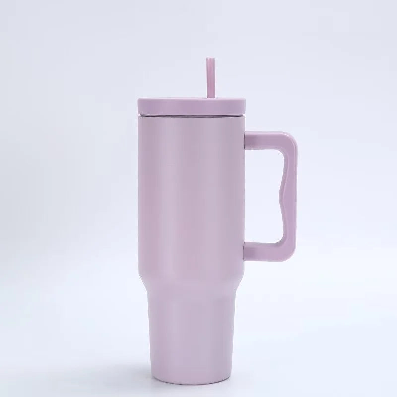 Tasse isotherme en acier inoxydable violet clair avec une paille rose.