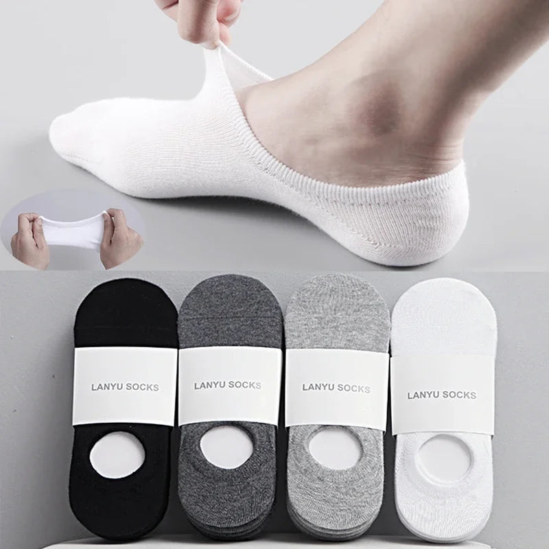 A set of white, invisible silicone no-show boat socks shown on a foot and laid out for display.
