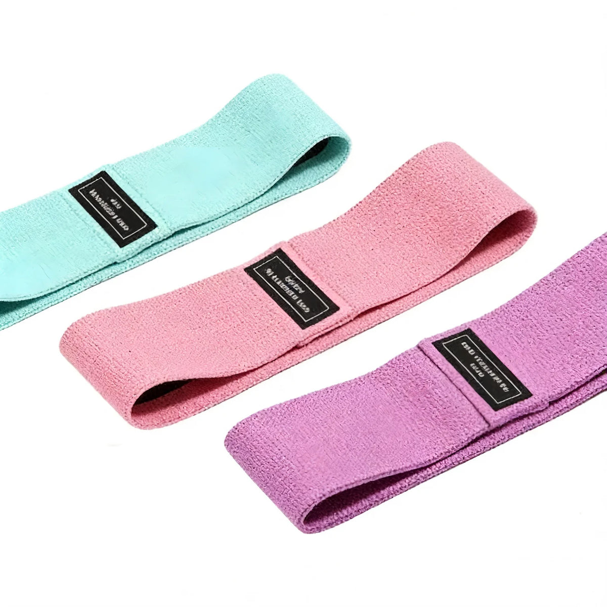 Three fabric resistance bands in mint green, pink, and purple laid out for a workout.