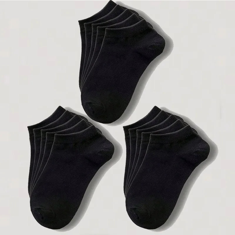 Una pila de calcetines de algodón unisex negros y transpirables, vista desde arriba.