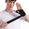 A young man demonstrates a flexible black thumb splint wrist brace for joint support on his hand.