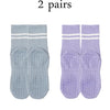 Two pairs of light blue and purple grip socks for yoga and barre