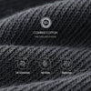Close-up of dark gray combed cotton knitted fabric showing texture and quality details.