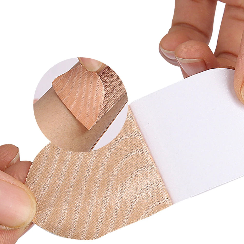 Eine Hand appliziert beige Kinesiologie-Tapes auf die Haut einer Person.