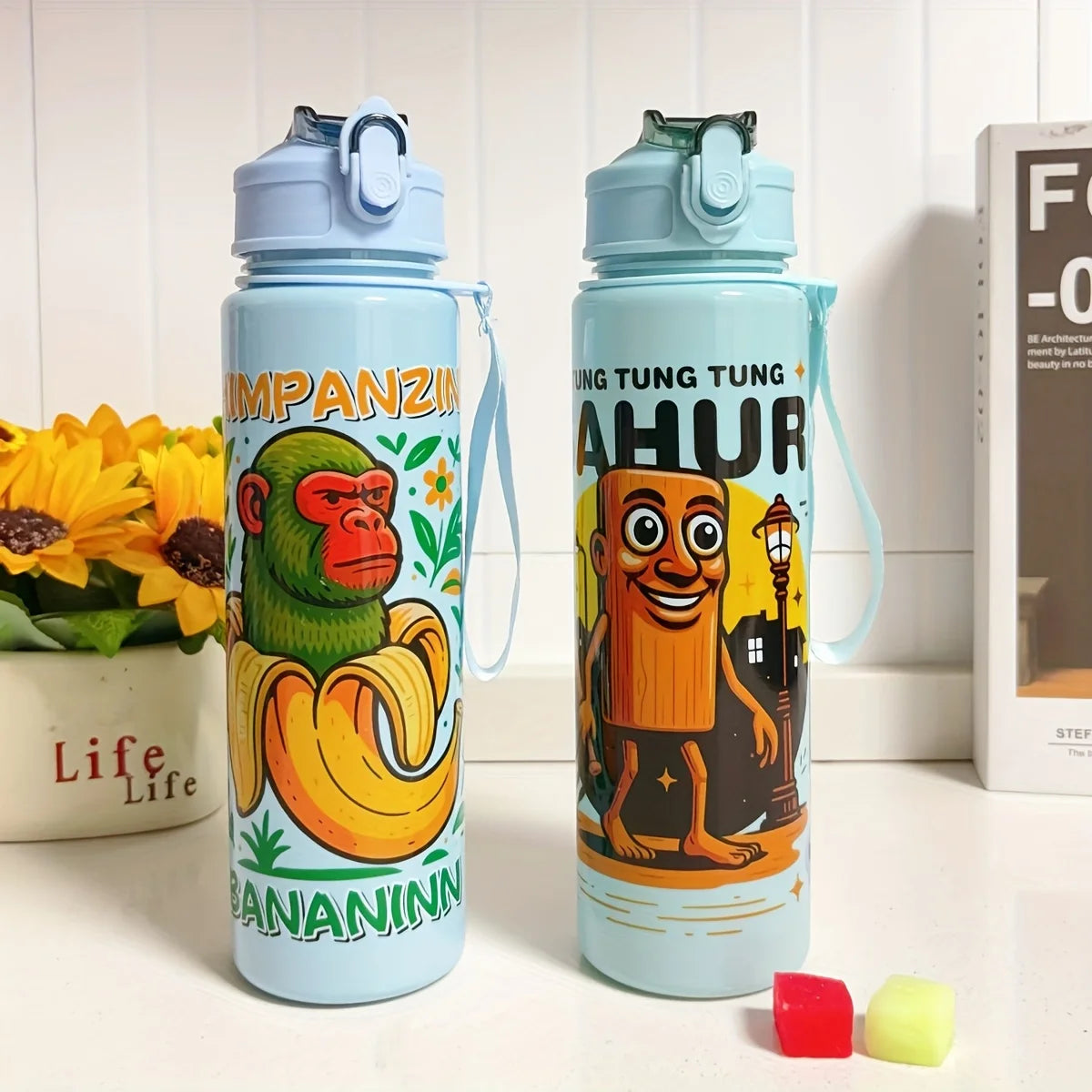 A light blue insulated sports water bottle featuring a green monkey design and the text IMPANZINANNN.