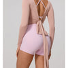 A woman wearing a long sleeve top and matching shorts in a dusty rose color, featuring a tie-front detail.
