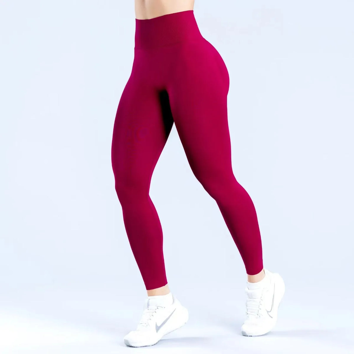 Model trägt hoch taillierte, nahtlose Yoga-Leggings in tiefem Magenta.