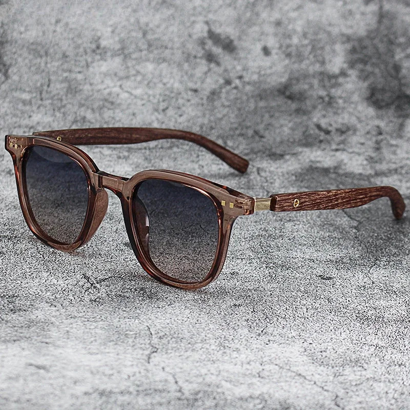 Brown wood grain polarized sunglasses with wooden arms resting on a gray textured surface