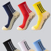 A collection of brightly colored performance sports grip socks displayed in various shades including navy, red, yellow, black