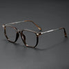 A pair of retro brown-tinted anti-blue light glasses resting on a dark surface.