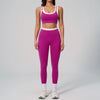 Eine Frau modelliert ein zweiteiliges Yoga- und Gym-Trainingsanzug in Magenta und Weiß.