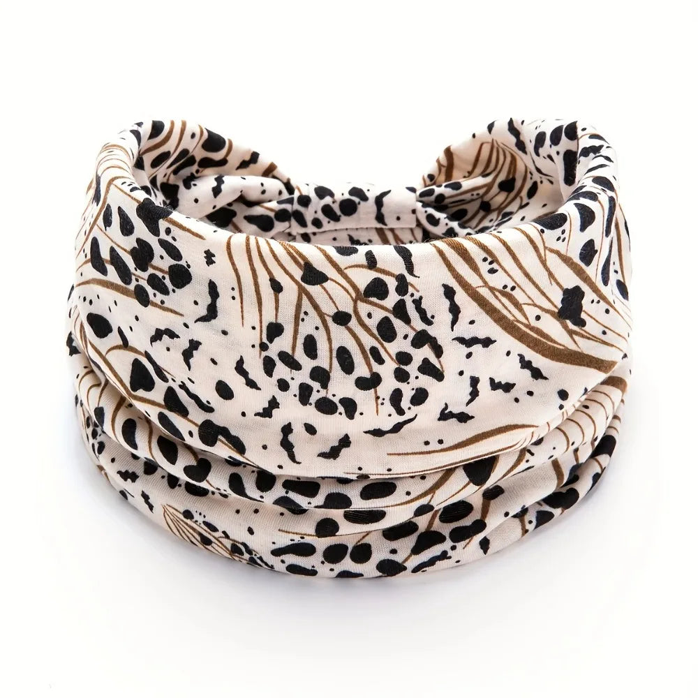 A close-up of a beige and black leopard print fabric headband rolled into a coil.