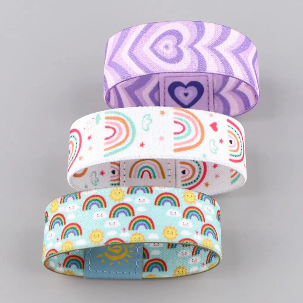 Colorful LGBT stretch wristband bracelet featuring patterns of hearts and rainbows in purple, white, and light blue.