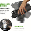 A hand holds a dark insulated water bottle with a leakproof spout lid and wide mouth for adding ice cubes and fruits.