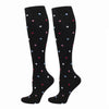 A pair of black compression elastic socks with scattered colorful dots.