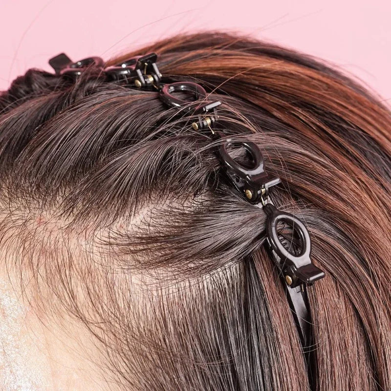 Primer plano de un peinado castaño oscuro adornado con una diadema y clip para flequillo doble negro.
