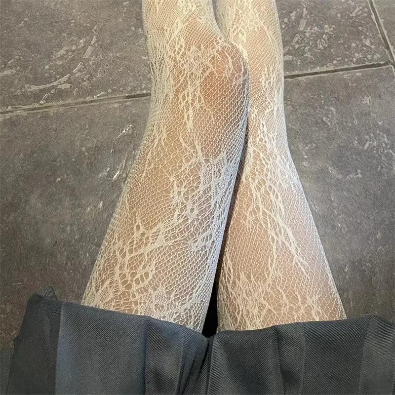 Pair of sheer floral rattan fishnet hosiery worn under dark trousers.