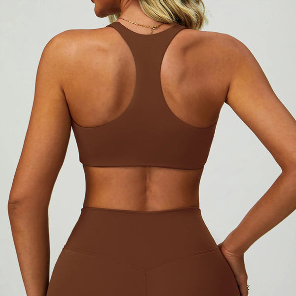 Un modèle portant un soutien-gorge de sport en yoga marron rembourré, à col arrondi et ajusté.