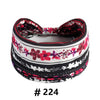 A black and white patterned fabric turban headband with a red floral design.