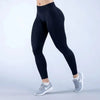 Une personne portant des leggings de yoga noirs à taille haute et des baskets grises.