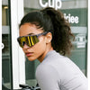 A woman wearing polarized performance sunglasses while riding a bicycle.