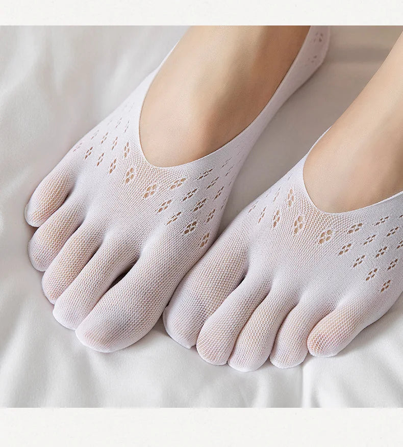 A pair of light pink, ultra-thin invisible boat socks are shown on a person's foot against a white background.