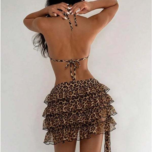 A woman wearing a leopard print bikini set with a tied knot back and ruffled skirt.