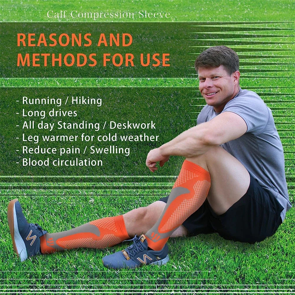 A man wearing orange calf compression sleeves is sitting on grass, demonstrating the product for use.