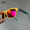 Gelbe polarisierte Sonnenbrille mit türkisem Rahmen und roter Aufschrift am Arm, gehalten von einer Hand.