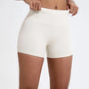 Un mannequin porte un short de yoga et de sport à taille haute, de couleur beige clair.