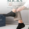Nahaufnahme eines Fußes mit schwarzen Socken neben einer Hose.