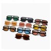Una colección de gafas de sol cuadradas ligeras en tonos verde, negro, marrón y ámbar.