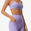 A woman wearing a lavender high-waist yoga and workout set consisting of a cropped top and matching shorts.