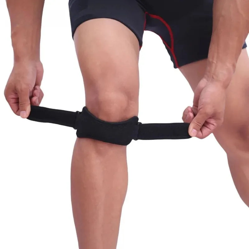 A person is applying an adjustable knee patellar tendon support strap to their leg.