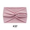 A folded dusty rose fabric headband or turban for women.