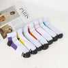 A collection of white ankle compression socks with colorful stripes and black tips displayed on a white background.