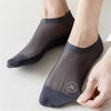 Gros plan de chaussettes en maille gris foncé antidérapantes portées sur un pied.