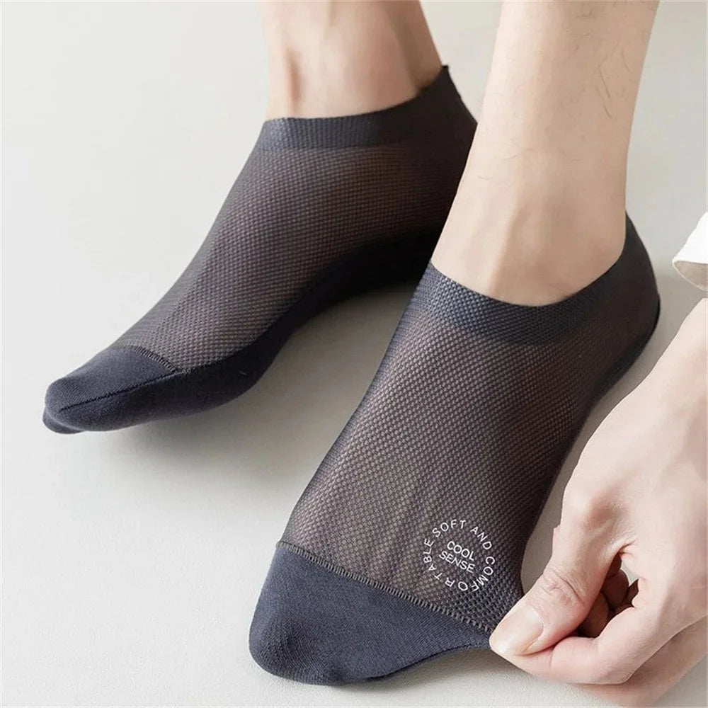 Gros plan de chaussettes en maille gris foncé antidérapantes portées sur un pied.