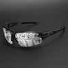 A pair of black wraparound sports sunglasses with clear lenses resting on a dark surface.