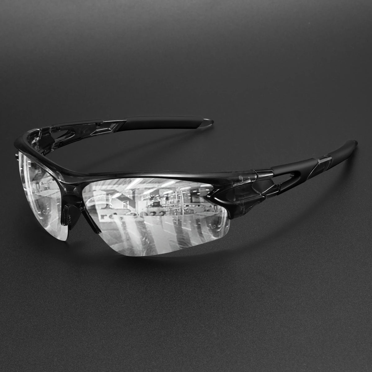 A pair of black wraparound sports sunglasses with clear lenses resting on a dark surface.
