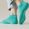 A pair of teal ankle boat socks worn on a person's foot and ankle.