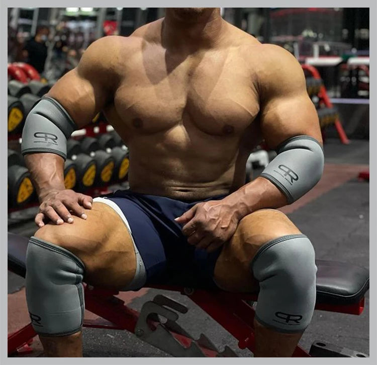 A muscular man wearing grey neoprene knee pads is sitting on a red weight bench.