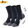 Three pairs of black performance running socks with gray grips shown standing upright.